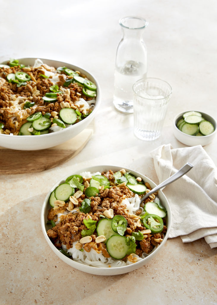 spicy pork + peanut butter pasta served with cucumber, cilantro, jalapenos and chopped peanuts