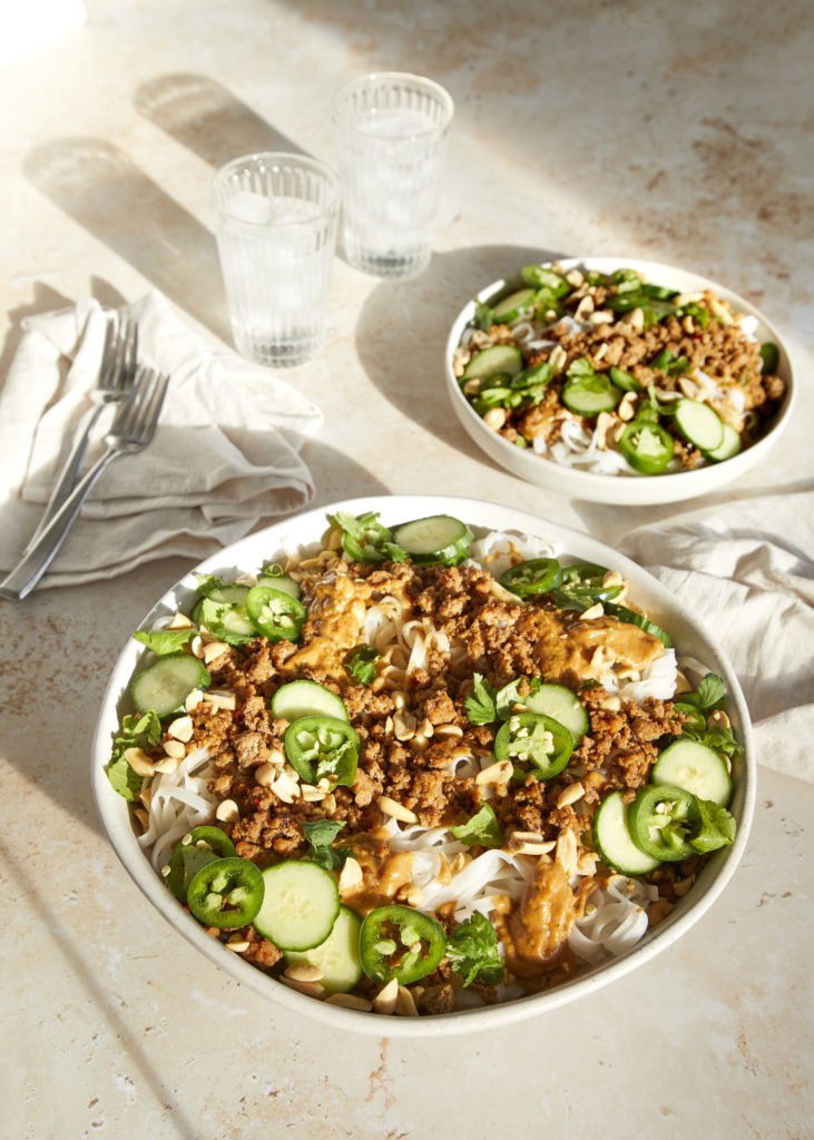 spicy pork + peanut butter pasta served with cucumber, cilantro, jalapenos and chopped peanuts