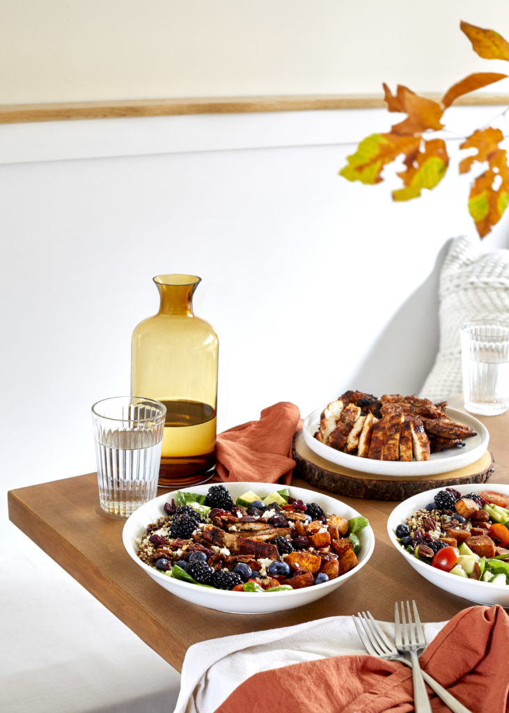 spicy chicken grain bowl filled with spicy chicken, coconut quinoa, cinnamon sweet potatoes, cucumbers, pecans, blackberries, cherry tomatoes and a  balsamic glaze