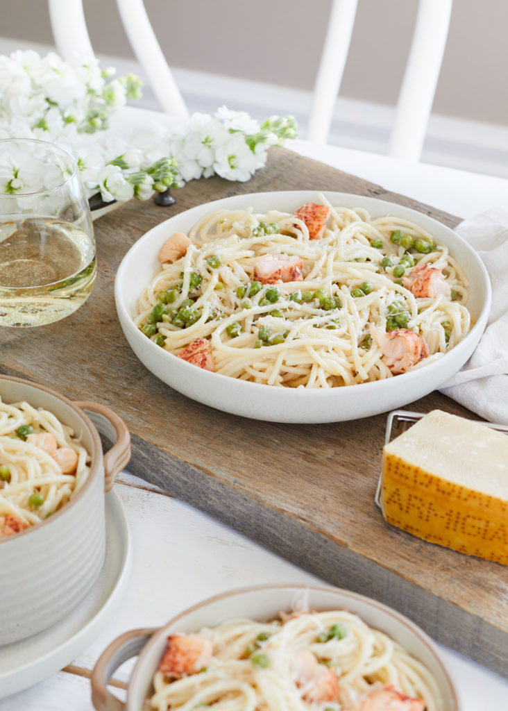 parmesan and garlic lobster pasta topped with green peas and extra parmesan