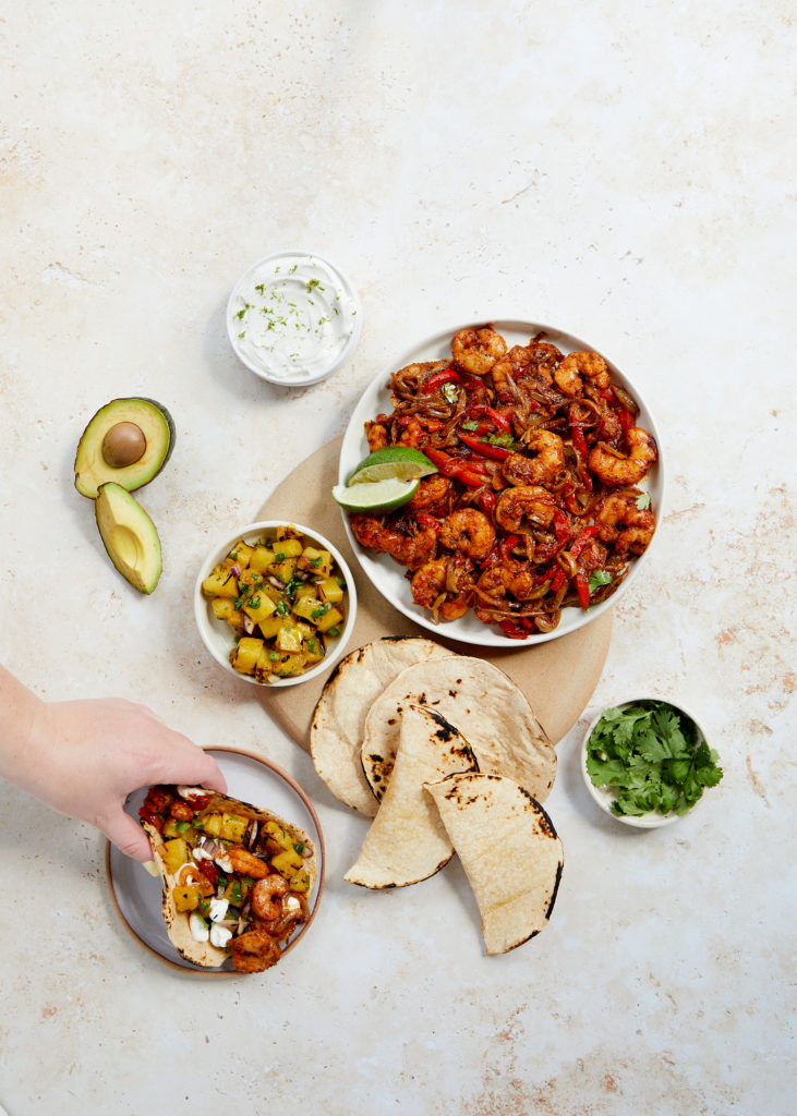 cajun shrimp fajitas with pineapple salsa, avocado, corn tortillas, lime and chips